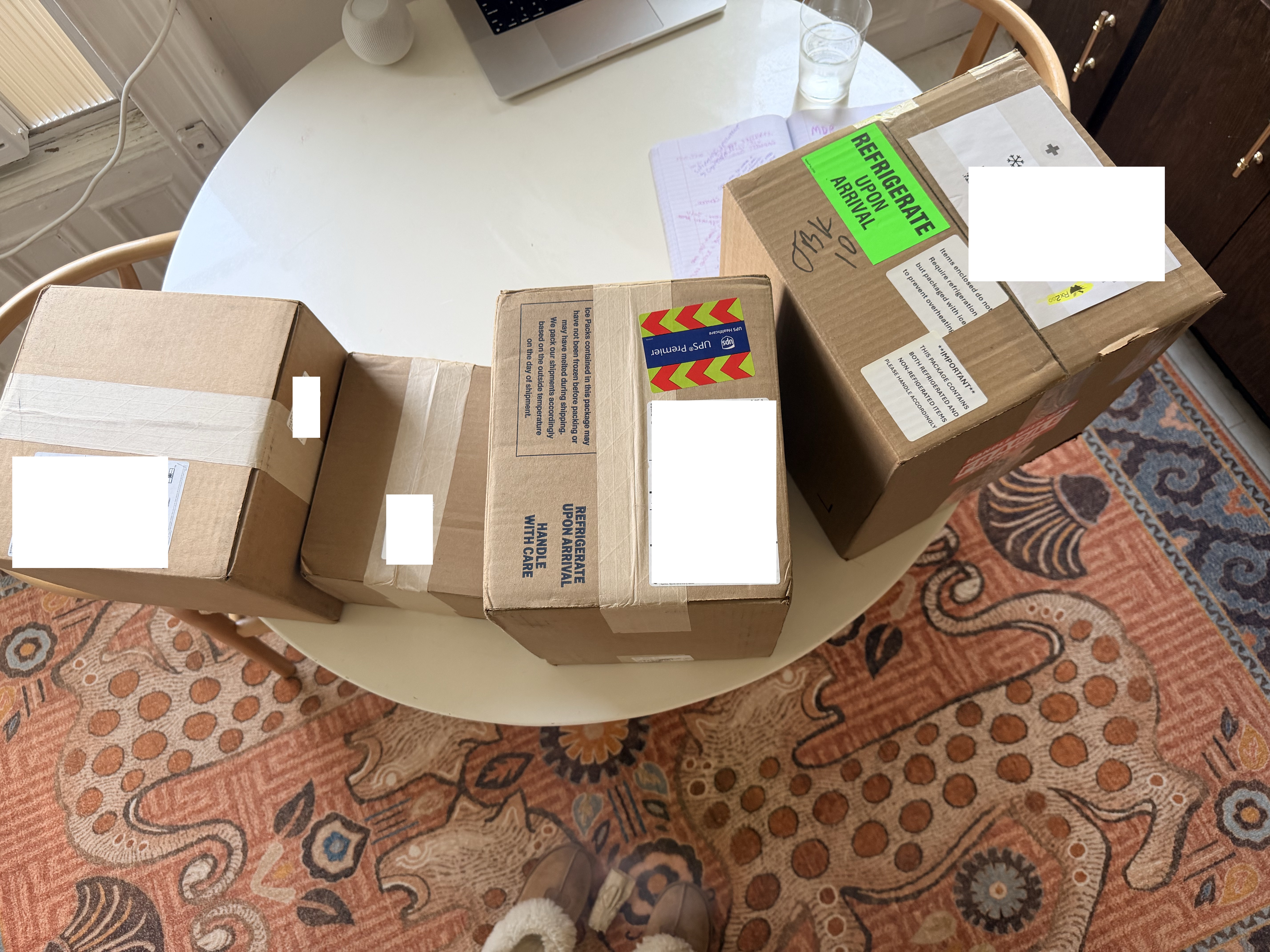 Overhead view of egg freezing medication boxes including one labeled REFRIGERATE