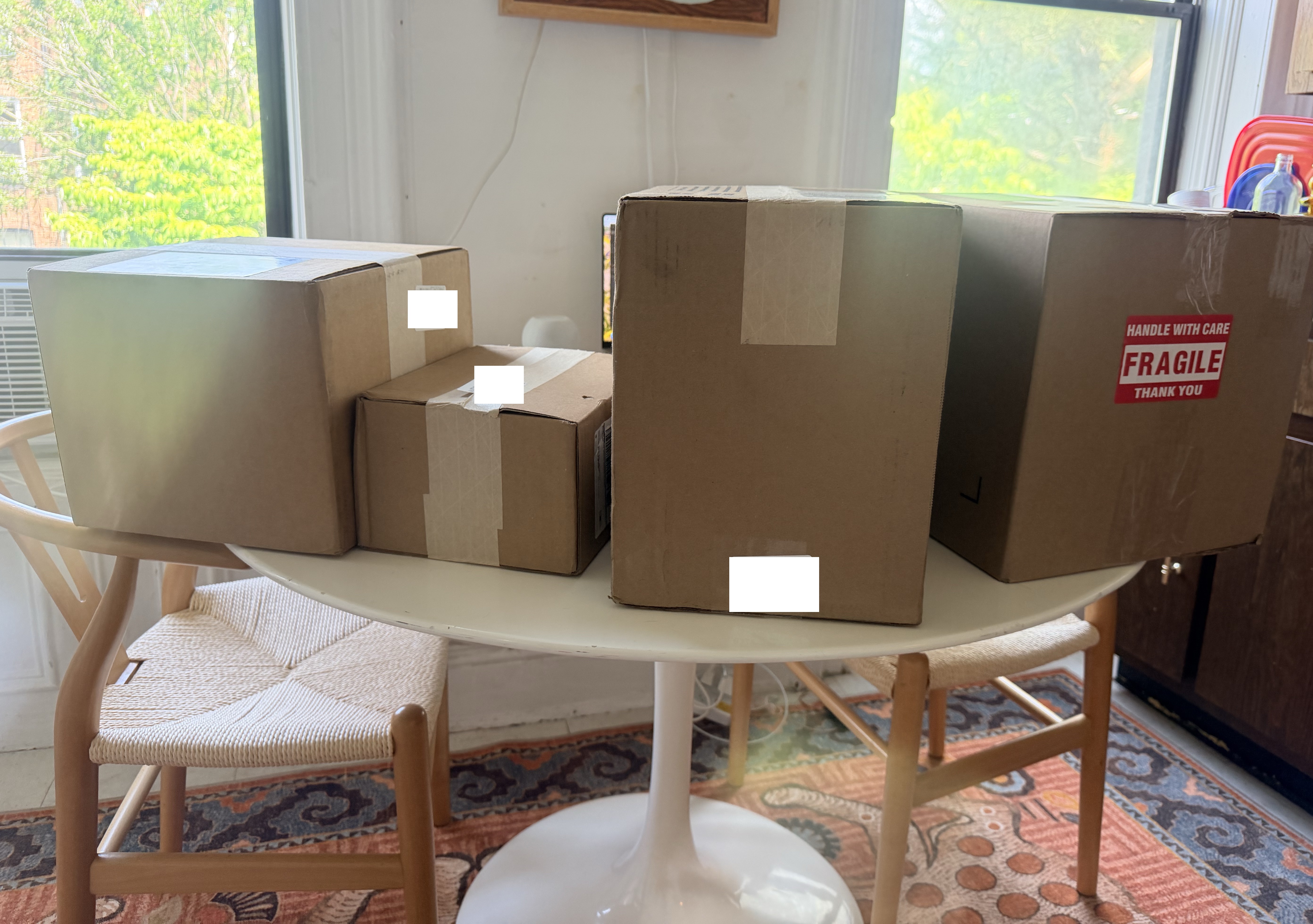 Four fertility medication boxes spread across dining table after delivery